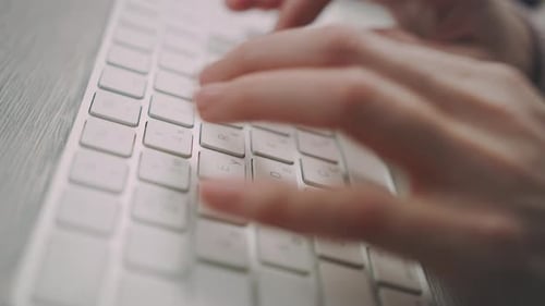 Female hands skillfully typing on a modern computer keyboard at the office
