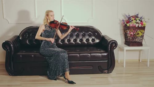 Woman plays Violin on a Leather Couch