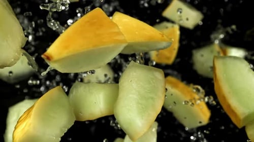 Melonenstücke fliegen auf schwarzem Hintergrund, gefilmt mit einer Hochgeschwindigkeitskamera mit 1000 Bildern pro Sekunde