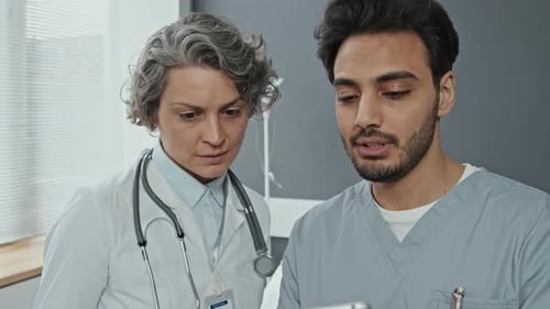 Doctors Collaborating Using Tablet in Hospital Setting