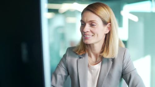Portrait happy cheerful business woman in office workplace talking online remotely on video call sit