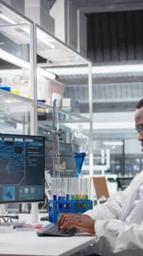 Scientist Types at Computer in Modern Laboratory