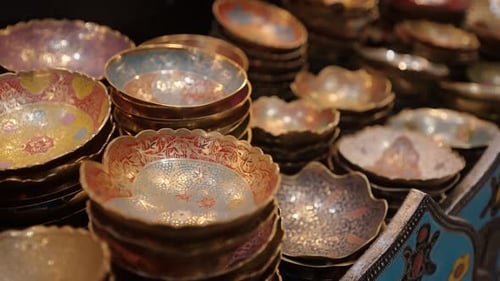 Handcrafted Moroccan decorative bowls with colorful floral patterns displayed in a market stall.