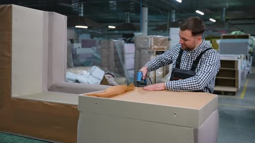 Man Stapling Upholstery Fabric on Sofa Base