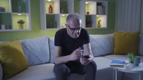 Der alte Mann mit schlechtem Sehvermögen. Hat Schwierigkeiten, das Telefon zu benutzen.