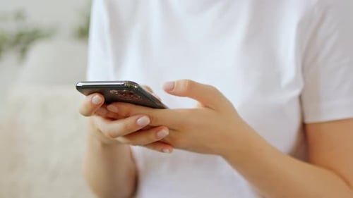 Woman using cell phone indoors during the day
