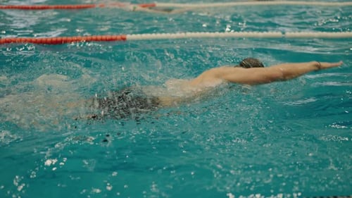 Hombre atlético nada en estilo libre en la piscina