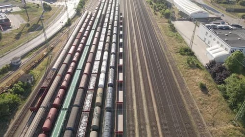 Aerial view of a railway station with multiple freight trains parked on the tracks. The surrounding