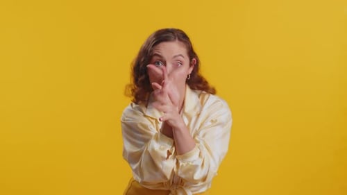 Woman Makes Funny Faces on Yellow Background