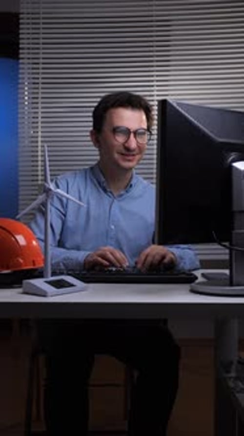 Vertical Video Male Engineer Working on a Computer in an Office Focusing on Sustainable Energy