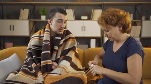 Woman Giving Medicine to Sick Man at Home