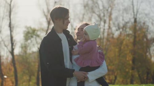 Father Holding Child in Park Parent Bonding During Autumn Outdoors Affectionate Father Cradling