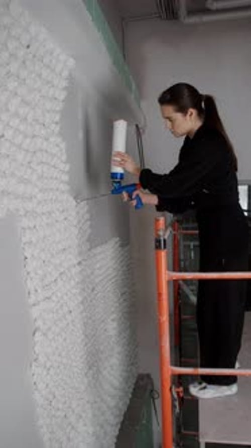 Une jeune décoratrice brune travaille sur un chantier de construction vertical