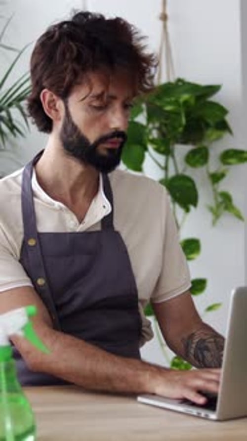Small Business Entrepreneur Owner Male of Plant Shop Working on Laptop Computer