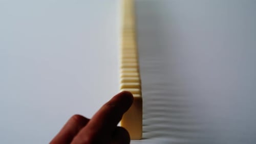 Hand Destroying Domino Row on Surface Closeup Unrecognizable Man Pushing Blocks