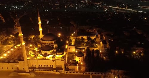 Aerial video at night over a mosque in Istanbul Turkey with the city in the background