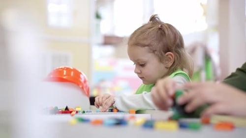 Two Children Building with Colorful Toy Blocks