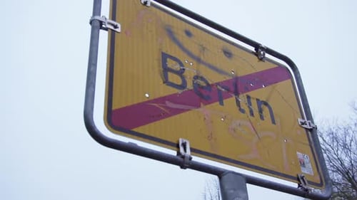 Leaving Berlin Town Sign with Funny Smiley on it on Cloudy Day