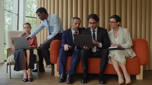 Diverse Business Professionals Working Together on Laptops