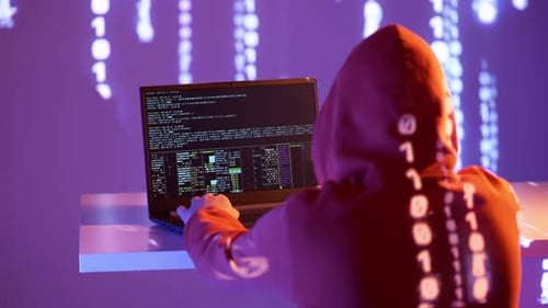 Hacker dans le capot codant la nuit avec projection binaire et interface de ligne de commande dans une pièce violet fluo