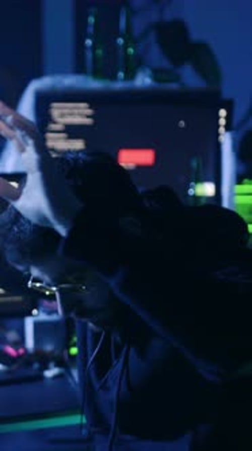 In einem dunklen Raum erkunden Einzelpersonen Spiele und Technologie, die sich auf Bildschirme konzentrieren