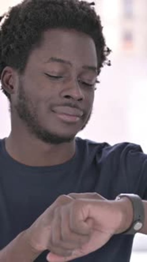 African Man using Smartwatch in Office, vertical video