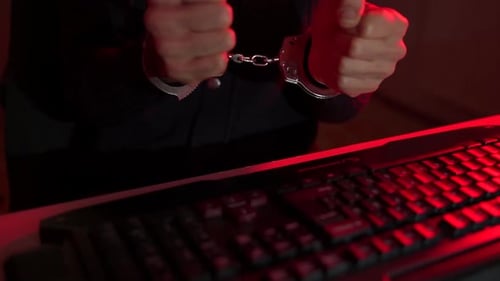 Hands in Handcuffs by Keyboard at Night