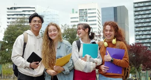 Smiling Students on University Campus Holding Folders