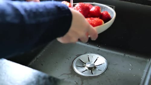 Strawberry wash.strawberries close-up under the jets of water from the tap.