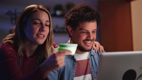 Smiling Couple Shopping Online With Laptop at Home
