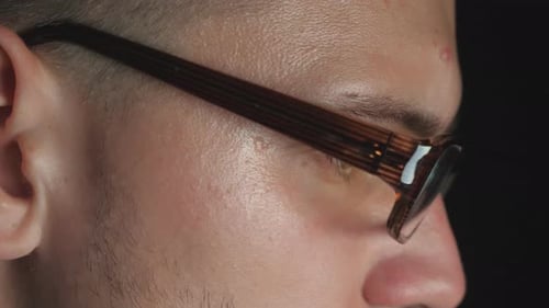 Close Up Male Eyes of Entrepreneur in Eyeglasses with Reflection of Screen Lights Working on Laptop