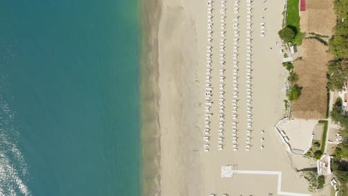 Sandy Beach with Umbrellas Ready for Morning in Summer Vertical Aerial