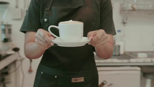 Jovem barista voltada para o serviço trabalhando em uma cafeteria