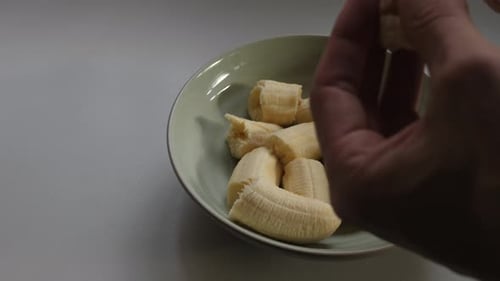 Person pouring vanilla essence onto metallic spoon and sprinkling over flour and baking mix. Slow mo