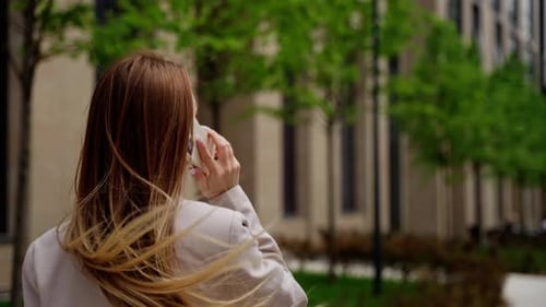 Woman Talking on Cellphone Walking in Urban Setting
