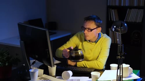 Man Working at Computer Drinking Coffee Late Night