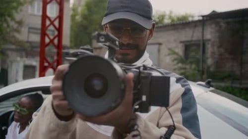 Man Holding Camera on Urban City Street