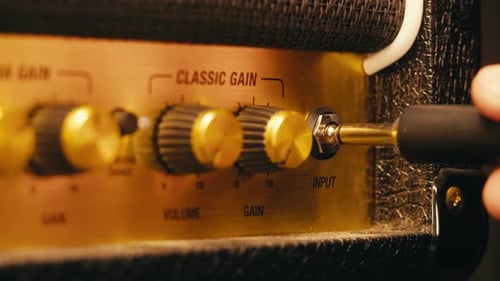 Hand Plugging Amplifier Cord and Adjusting Volume