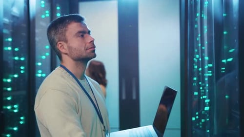 Man Working on Laptop in Server Room
