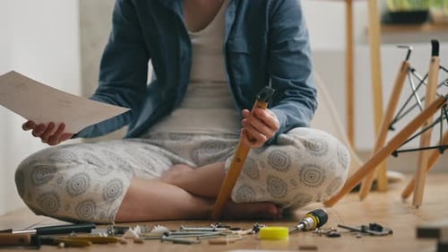 Person Assembling Furniture Leg on Floor