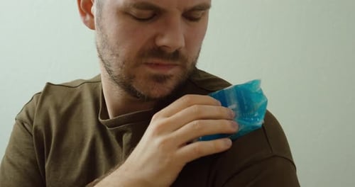 Homme tenant une compresse froide sur l'épaule — Thérapie rafraîchissante pour les douleurs musculaires