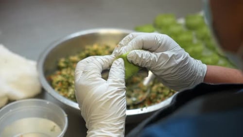 Chef properly folds traditional chinese dumplings closed, hands prepare veggie dumplings, close up s