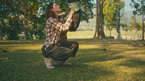Woman Playing with Dog in a Green Park