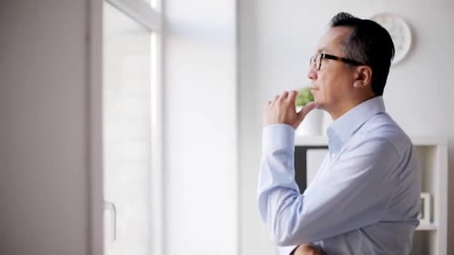 Businessman Thinking and Looking Through Window at Office Asian