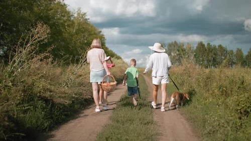 Family Walking on Dirt Road with Dog During Countryside Retreat