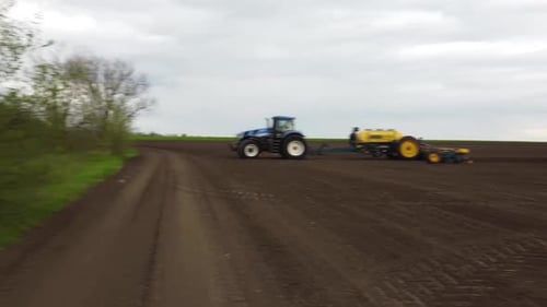 Blue tractor OA working on the field in Ukraine