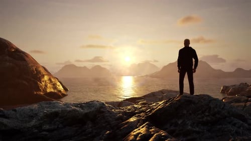 Man Standing on Rocky Shore on Ocean Coast Magical Mountain Scene in Nature at Sunrise