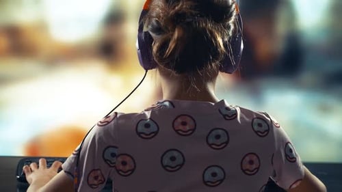 Child Plays Video Game with Headphones Indoors
