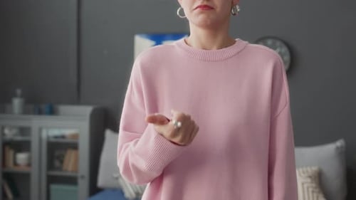 POV of Woman Speaking Sign Language at Camera Standing Indoors
