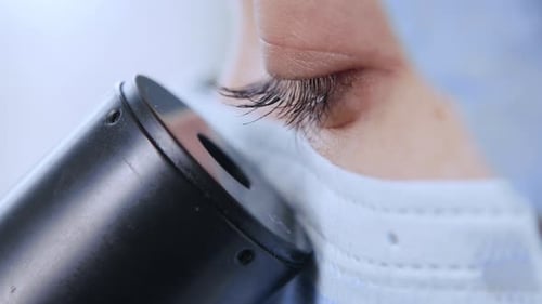 Eye Looking into Microscope in Hospital Laboratory